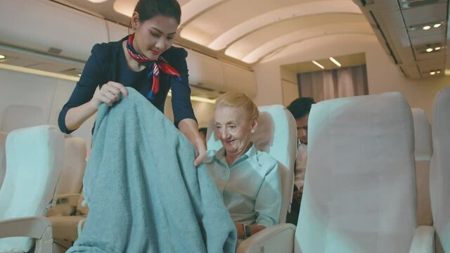 A beautiful woman cabin crew is smile greeting to passengers onboard , lifestyle and business travel concept