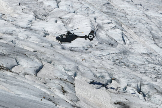 Swiss Airforce EC 635 Helicopter flying over a glacier