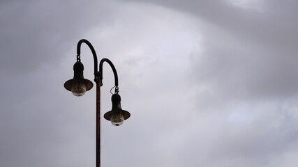 rustic street light against cloudy sky