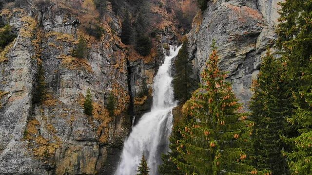 Drone flying over a green forest around a big waterfall in the mountains. Aerial Drone footage 4K. Beautiful nature landscape scene showing the famous waterfall in the Carpathian Mountains, Vanturis