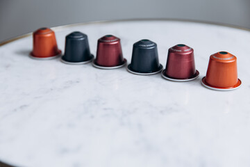 Six colorful pods for coffee machine standing in row
