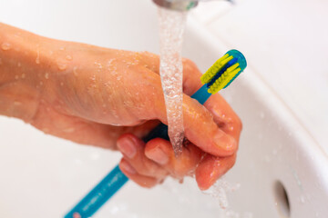 Fototapeta premium special toothbrush under the running water in bathroom