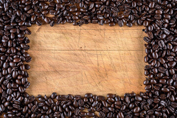Coffee bean on wooden board with copy space in middle