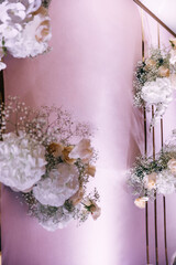 photo zone is a stylish wedding decoration with flowers, mini flowers, gold letters on a handmade pink background. Place for photography