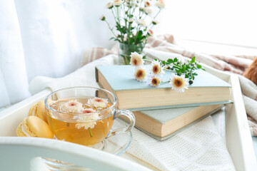 Cup of tea, macaroons, chrysanthemum flowers and books