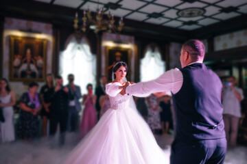 Happy bride and groom and their first dance, wedding in an elegant restaurant with wonderful light and atmosphere