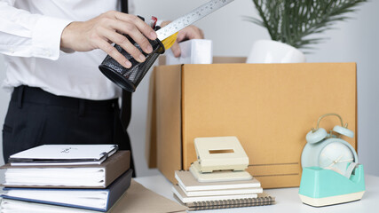 Put the work equipment in the office in a large brown box, Businessmen are keeping work documents and personal belongings due to resignation or being fired, termination of employment.