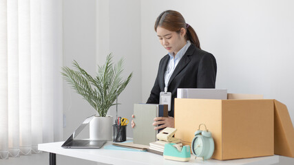 Put the work equipment in the office in a large brown box, Businessmen are keeping work documents and personal belongings due to resignation or being fired, termination of employment.