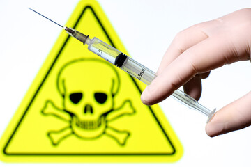 Syringe filled with liquid on white background with danger symbol