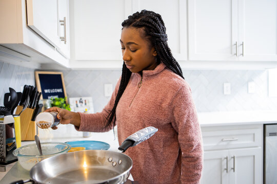 Teen Girl Preparing Family Breakfast On Saturday Morning