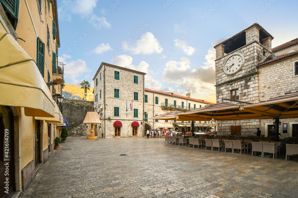 Wall mural a tour group stands together early in the morning in the square of the arms in the medieval town of 