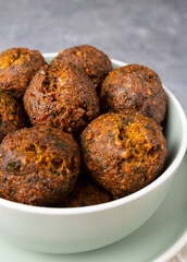 Falafel balls in a mint bowl on a plate. Vegan snack in a deep bowl