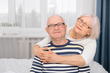 portrait of senior woman hugging senior man at home. couple in love