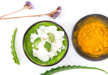 Coconut oil, aloe and turmeric natural herbal skin care products, top view ingredients. Facial and body treatment