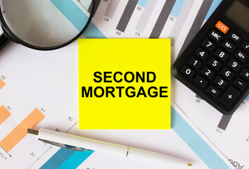 Yellow sticker with text Second Mortgage with calculator white pen magnifying glass on the diagrams