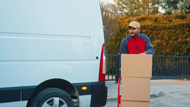 delivery men unloading cardboard boxes from truck on street. High quality 4k footage