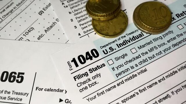 Tax refund and return concept, tax form 1040 close up video with cash and golden coins, business deals