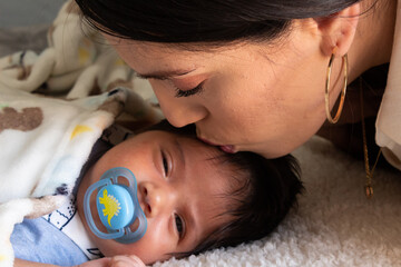 beautiful portrait of a young hispanic mother with her newborn baby