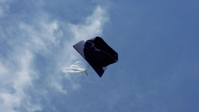 Single graduation cap flying in the air. Virtual graduation, social distancing, stay home concept.