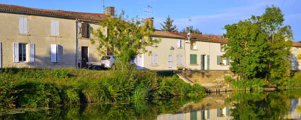 Fototapeta na wymiar Panoramique Damvix (85420) se reflète dans la Sèvre Nortaise, département de Vendée en région Pays de la Loire, France