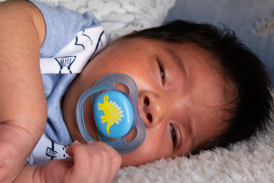 beautiful portrait of a newborn hispanic baby asleep in bed