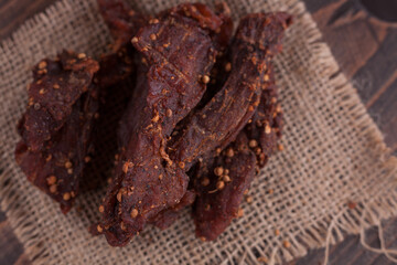 Organic Chilled Pork / Studio Shot. Dried meat with spices on sacking. Wooden background. Village motive.