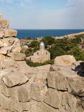 View from the wall of the medieval fortress of Kafa on the shore of the Gulf of Feodosia to the Temple of the Iveron Icon of the Mother God. Tourist attraction of the resort town.