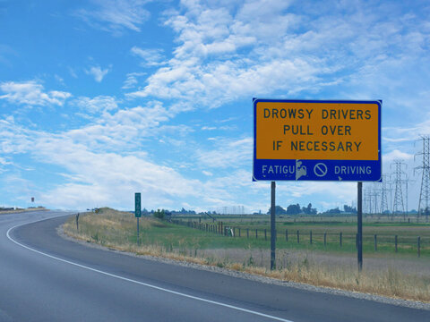 Roadside sign advising drivers to pull over if they are drowsy while driving.