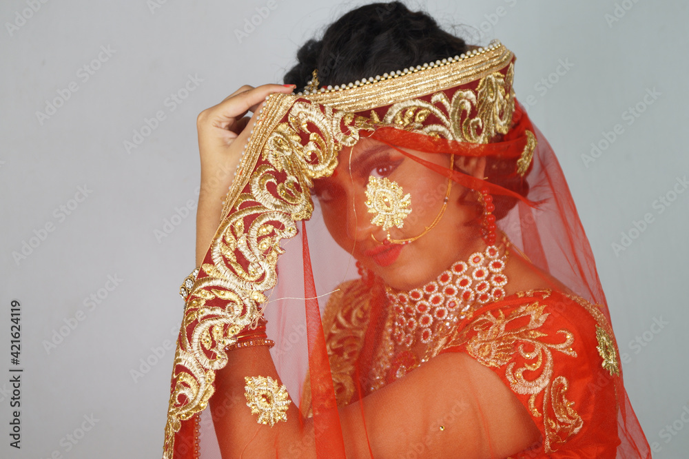 Poster Gorgeous Indian bride with heavy makeup wearing traditional Indian bridal attire and posing