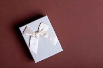 Craft gift box on a black background, decorated with a bow. For birthday, anniversary presents, gift post cards.