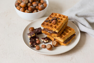 Chocolate spread with homemade waffles. Cup with hazelnuts.