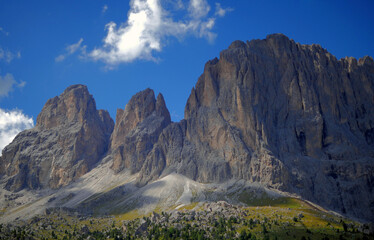 Large rocky mountains under a blue sky. Imposing mountains photographed from below. Panoramas of Trentino Alto Adige, Italy.