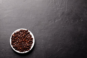 Cup of coffee with beans on table, top view