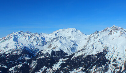 Fototapeta na wymiar Panoramic view of snowy mountain peaks in the Savoy Alps.