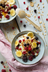 muesli with berries and yogurt on a light board