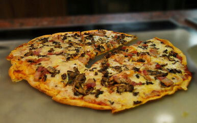 Pizza with very thin crust, bacon strips and mushrooms
