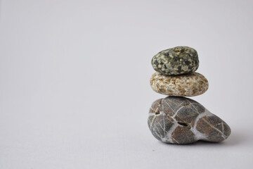 The stones of the pyramid are balanced on a white background. The object is in focus.