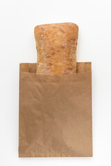 Ciabatta in a paper bag, on white background. Space for design.