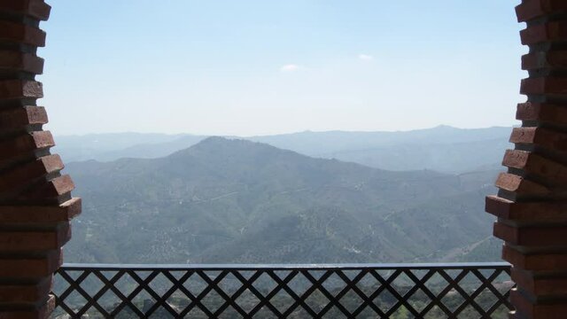 Horseshoe arch with mountains on an Arab wall a sunny day