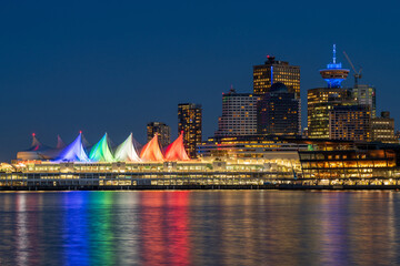 Fototapeta na wymiar Night view of Vancouver Harbour marina skyline. Downtown buildings colorful lights reflections on waterfront harbor. British Columbia, Canada.