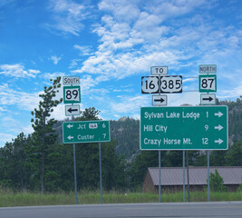 Roadside signs with directions to different destinations in South Dakota.