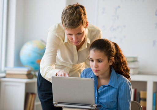 Teacher helping student in classroom