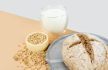 Cross buns bread Isometry diagonal projection creative beige background with green buckwheat bread nd organic buckwheat milk. Harmless, wellness, gluten free healthy baking. Alternative bread.