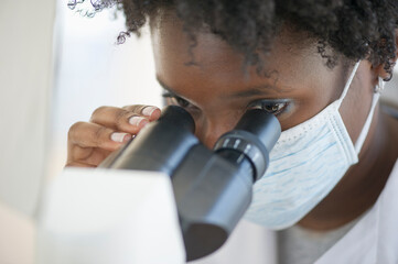 Researcher looking at specimen through microscope