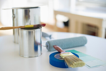 Cans of paint paint brushes roller and paint swatches