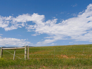 Fototapeta na wymiar Wyoming farmlands with a wire fence along the road.