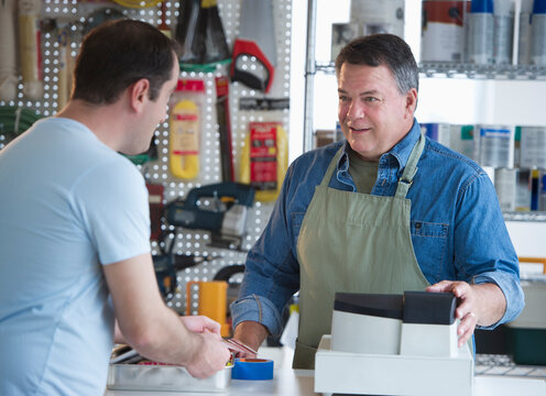 USA, New Jersey, Jersey City, Shop owner serving customer in hardware shop