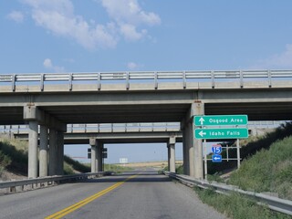 Obraz premium Bridges over the road with signs on the road leading to directions to Osgood Area and Idaho Falls, Idaho.
