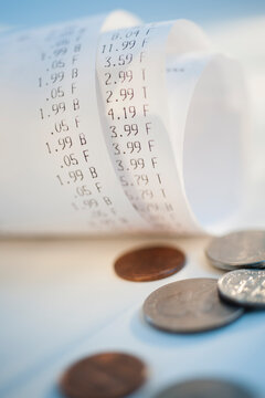 Coins by rolled up receipts with prices