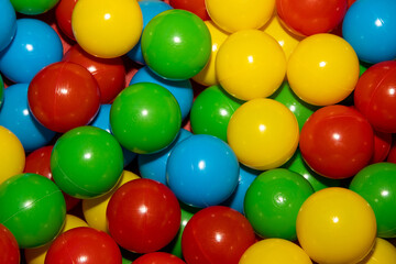 A close up of a bunch of colourful plastic balls in a children's ball pool pit
